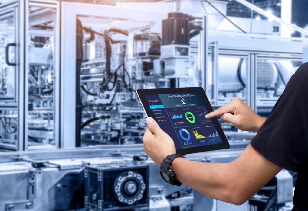 Manufacturing engineer with tablet reviewing live production data